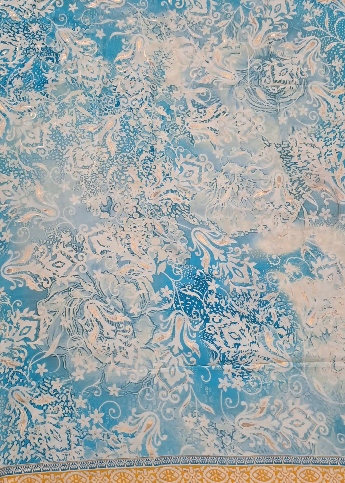 Decorative fabric with intricate patterns in blue and beige on a textured background