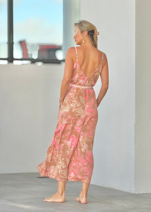Woman wearing a pink floral romper in a minimal outdoor setting