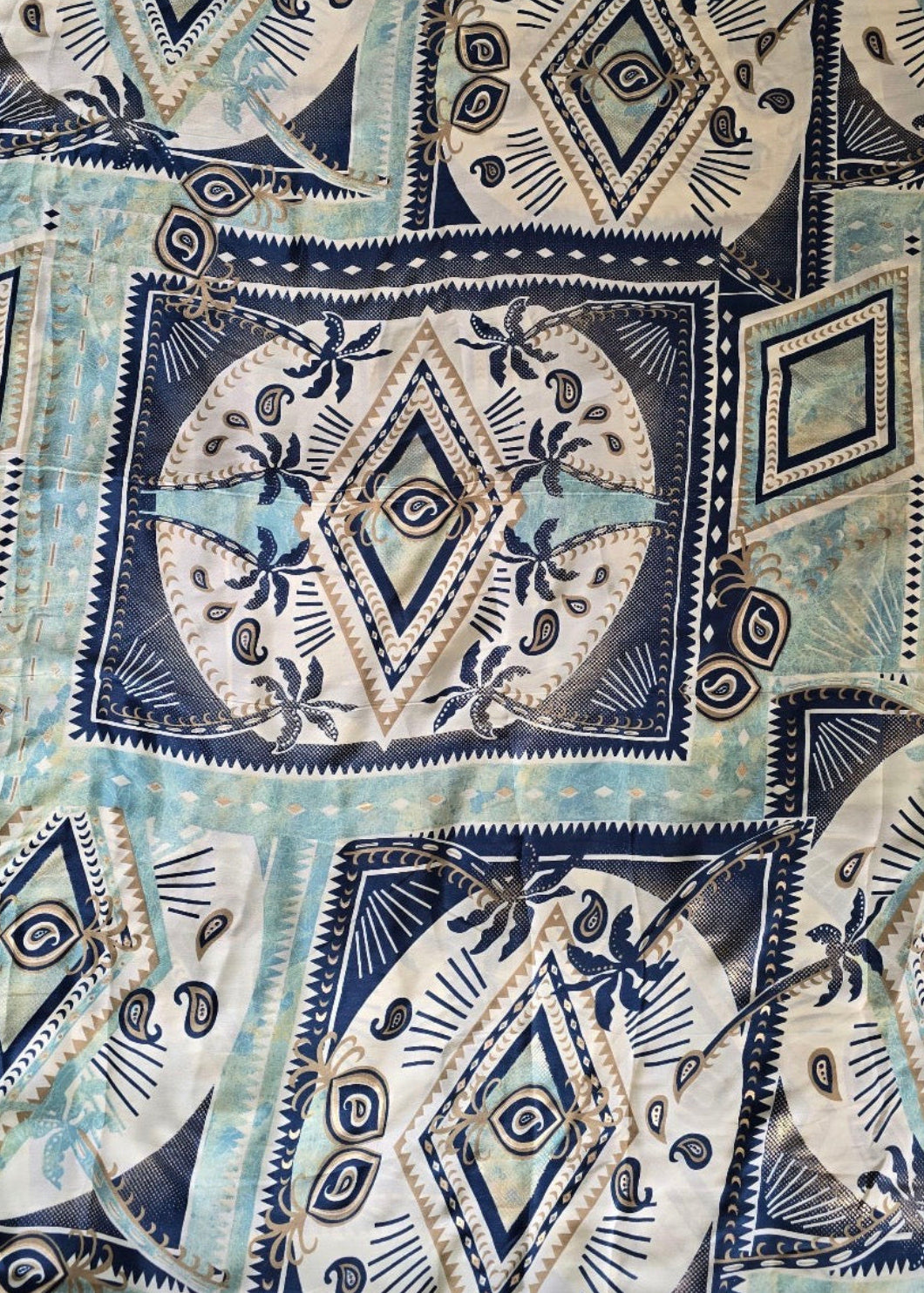 Patterned fabric with geometric and abstract designs in blue, white, and black.