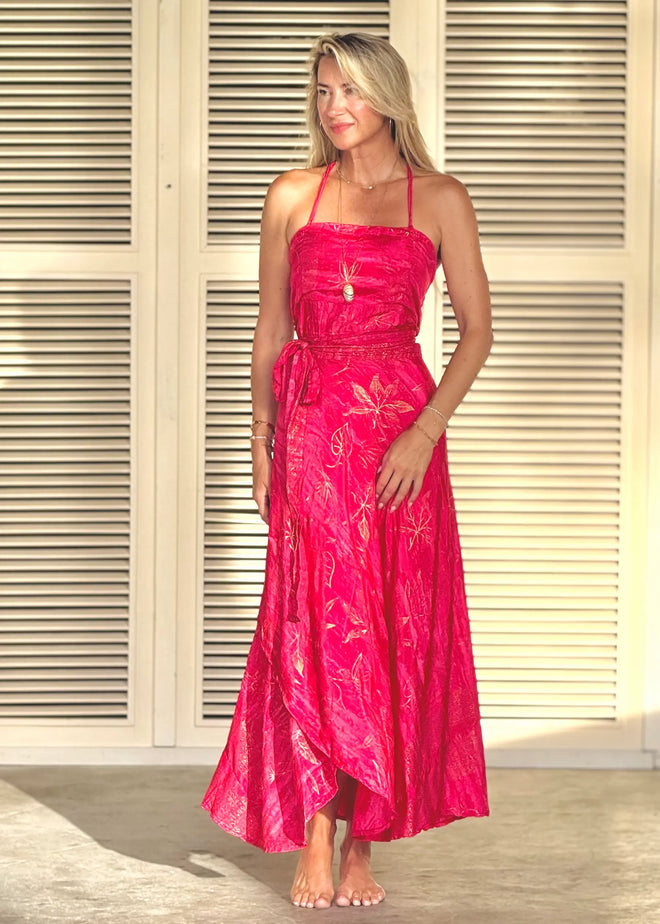 Woman wearing a pink dress standing in front of a neutral background